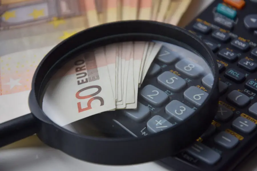Magnifying glass over euro bills and calculator