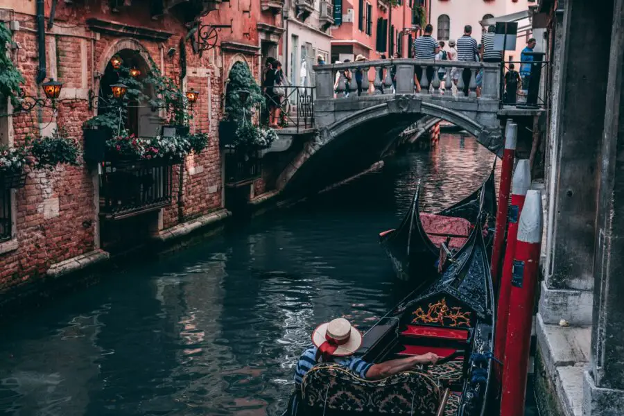 Man in Gondola, near a bridge in Venice
