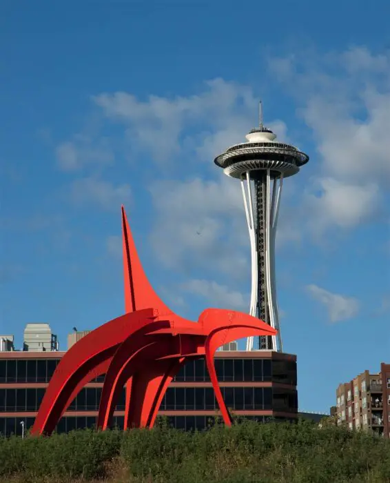 A view of the Seattle Space Needle and a red sculpture from the Olympic Sculpture Park in Seattle