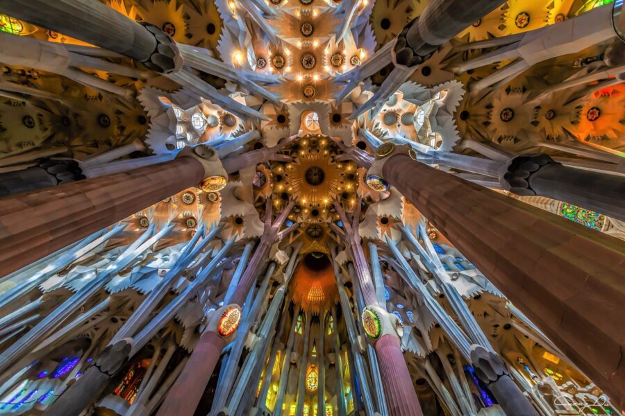 The colorful and funky ceiling, including long tanned pillars, of the interior of La Sagrada Familia in Barcelona, Spain - An essential stop on your 2 day Barcelona itinerary