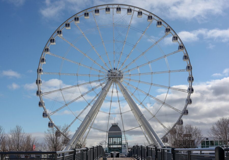 The large and majestic Grande Roue de Montreal on a cold day, with blue skies and wispy clouds visible in the back