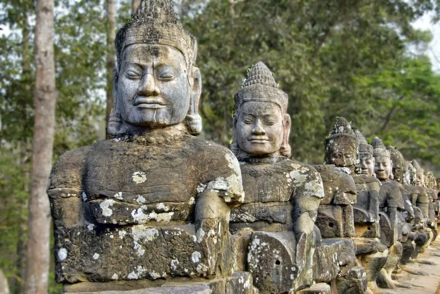 A line of grey stone statues on the road to Angkor Wat in Siem Reap