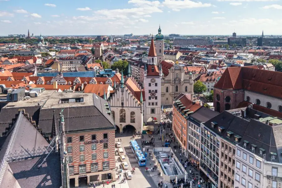 Several Munich churches and architecture seen from the New Town Hall tower, with Marienplatz below and the Munich skyline above