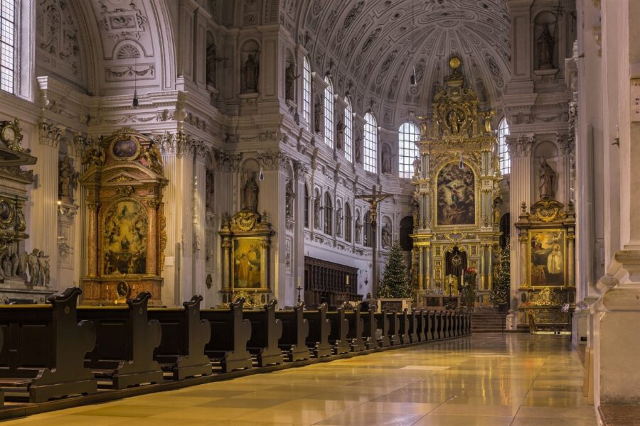 The extravagant and opulent white, bronze, and gold interior of Michaelskirche Munich