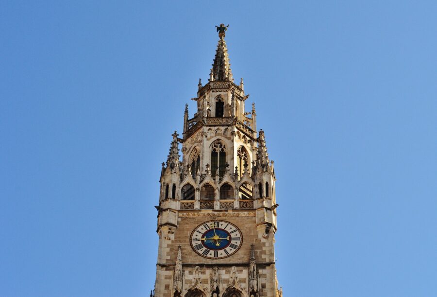 The pointed tower of the Munchner Kind at the New Town Hall in Munich surrounded by blue sky - the starting point of many walking tours in Munich
