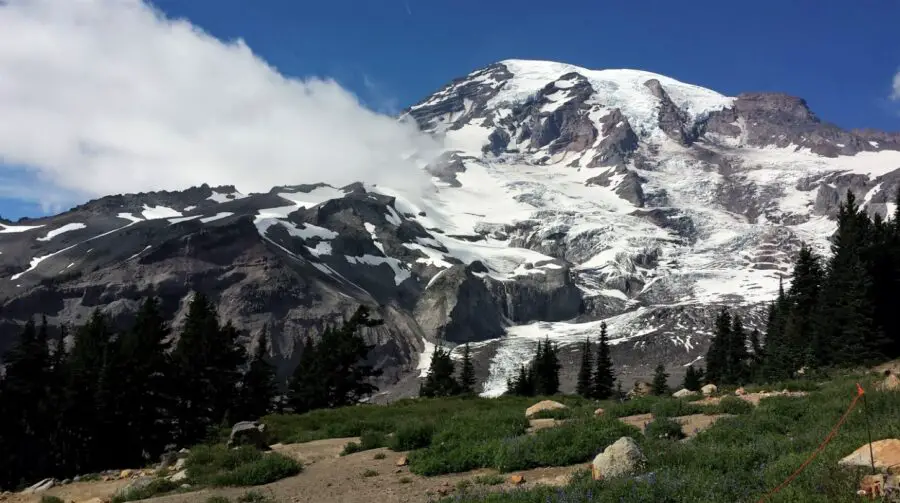 Mount Rainier in the summer, the snow-covered rocks surrounded by white misty clouds, one of the best weekend getaways from Vancouver
