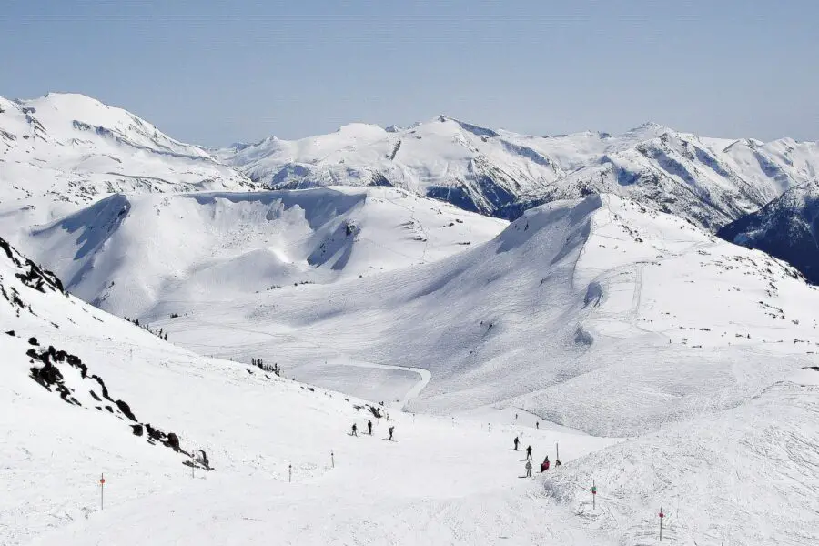 A few skiers on the roaming snow-covered hills and mountains of Blackcomb Whistler Skiing Resort, one of the best things to do in Whistler in winter