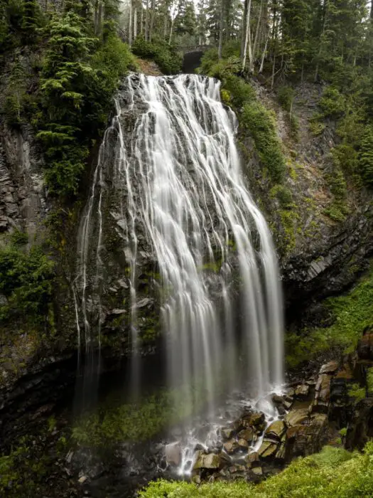 One of the Mount Rainier waterfalls, with the streaming white water going down the dark grey cliff