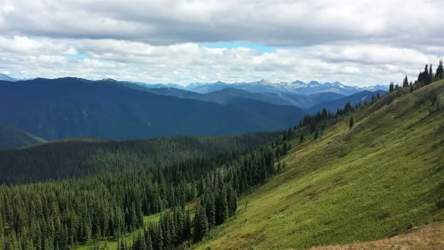 Views of distant mountains, lush forest, and a steep hill in EC Manning Park on a cloudy day, one of the best weekend getaways from Vancouver