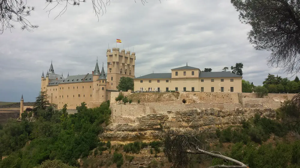 Side photo of the Segovia Alcazar located on the edge of a cliff on a cloudy day – a sight on my Segovia free walking tour.