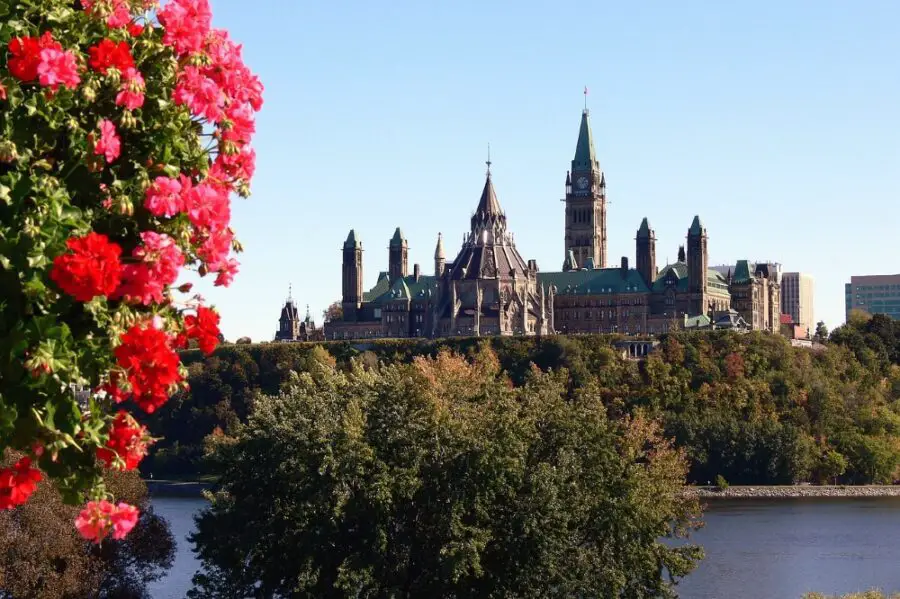 A view of Parliament Hill and the Ottawa River on a sunny day, a spot on our self-guided walking tour of Ottawa
