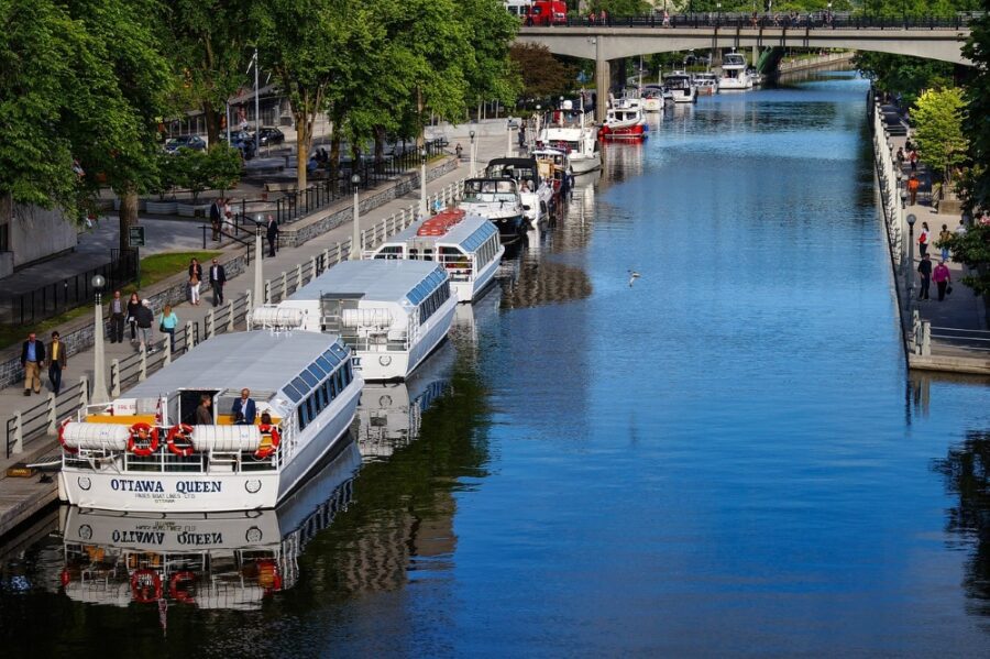 Several white, Ottawa river tour cruise boats on the Rideau Canal in Ottawa