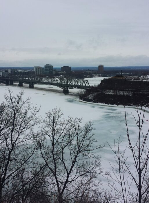 The frozen and snowy Alexandra Bridge and Ottawa River from Parliament Hill in the winter, one of the best sights on this walking tour of Ottawa