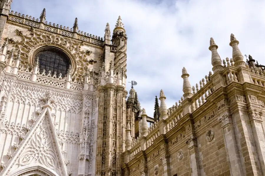 The intricate exterior of the Seville Cathedral on a cloudy day, one of the beautiful sights on my self-guided walking tour of Seville.