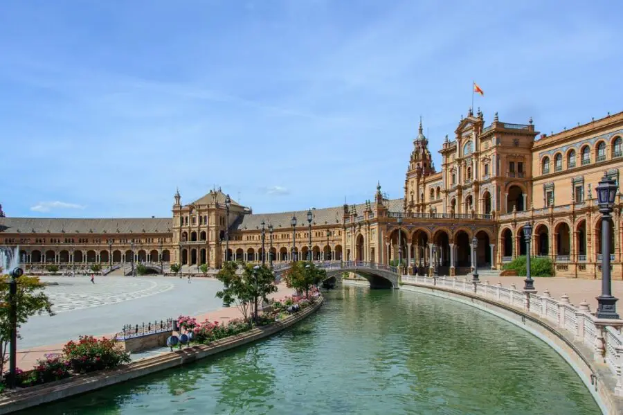 The nearly empty Plaza de Espana in Seville Segovia on a bright morning, with the turquoise water of the canal free of boats.